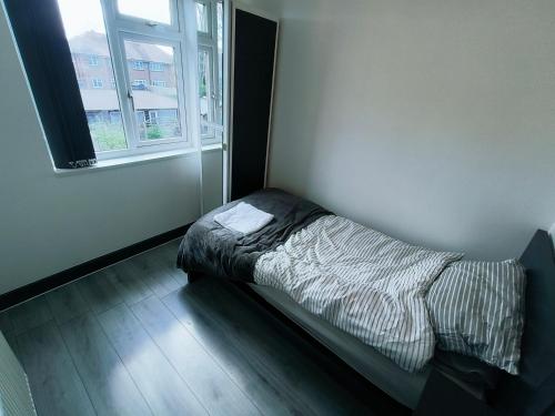 a small bed in a room with a window at Modern 3 bedroom house in Birmingham