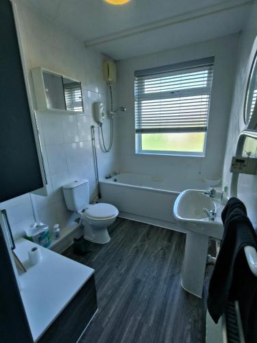 a bathroom with a tub and a toilet and a sink at Modern 3 bedroom house in Birmingham