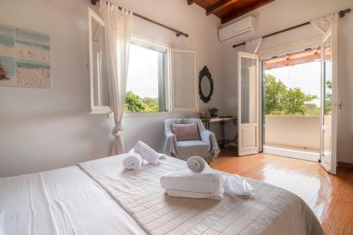 a bedroom with a large white bed with towels on it at Villa Diana in Acharavi