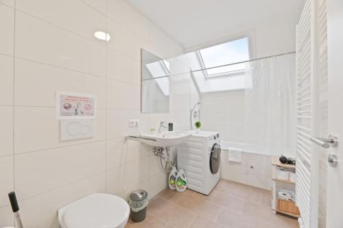 a white bathroom with a toilet and a sink at W02 Business Apartment für Teams in Wendlingen am Neckar