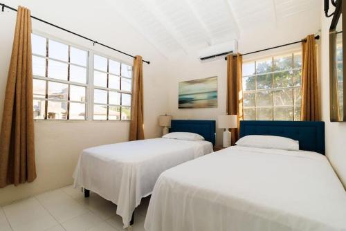 2 camas en una habitación con 2 ventanas en 2 Bedroom Apartment at Maynards en Saint Peter