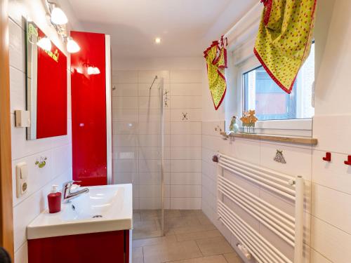 baño con lavabo y armario rojo en Ferienhaus am Ringweg, en Bad Schandau