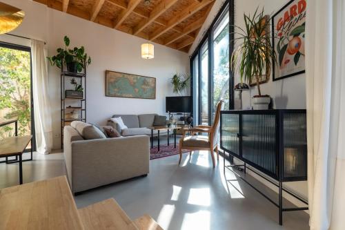 a living room with a couch and a table at Le Resort, charmante petite villa d'architecte in Saint-Jean-de-Védas