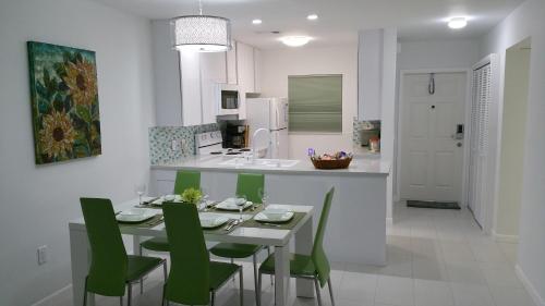 a kitchen and dining room with a table and green chairs at Downtown Hollywood Boutique Hotel in Hollywood