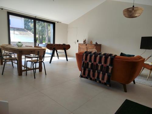 a living room with a couch and a table at Joyau au cœur de la forêt in La Guérinière