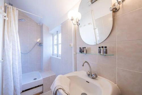 a white bathroom with a sink and a mirror at Amazing location only 3 minutes from Luxembourg Gargens in Paris