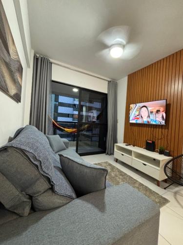 uma sala de estar com uma cama e uma televisão de ecrã plano em Infinity APT 503 em Maceió
