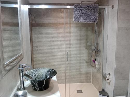 a bathroom with a sink and a shower with a bucket at El Balcón de La Juderia in Córdoba