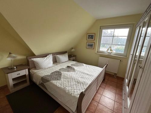 a bedroom with a bed and a window at K&S Ferienwohnungen in Dierhagen