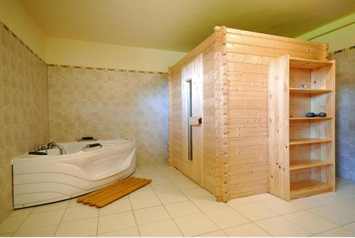 een badkamer met een bad en een douche. bij Penzion u Šeliho in Veľká Lomnica