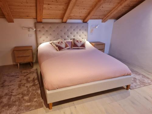 a bedroom with a large bed with pink sheets and pillows at La corte Antey Maison De Emilie in Antey-Saint-André