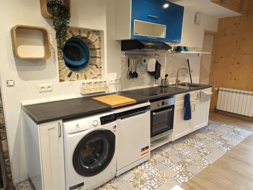 a kitchen with a washing machine and a sink at Le Domaine de la Férière in Sallen