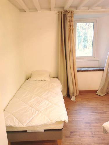 a bed in a room with a window at Le Domaine de la Férière in Sallen