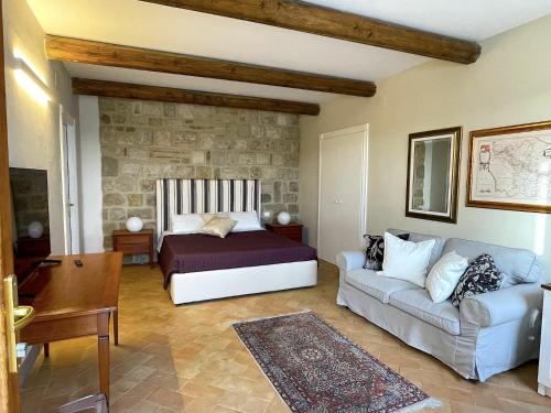 - une chambre avec un lit et un canapé dans l'établissement I Casali di Colle Monte, à San Giuliano di Puglia