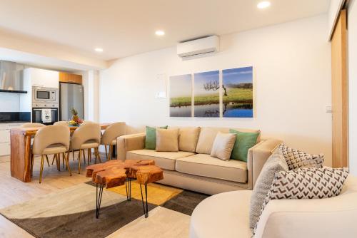 a living room with a couch and a table at Bella Vista (Heated Pool & Private Parking) in Arco da Calheta