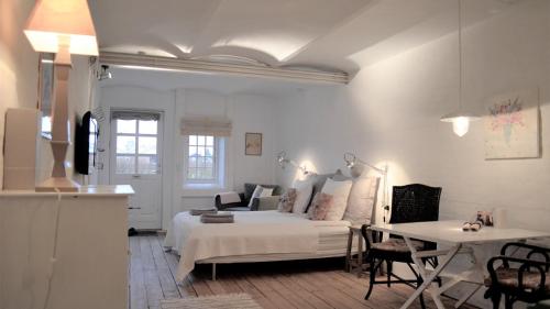 1 dormitorio con cama, mesa y sofá en Store Ejlstrup Bed & Breakfast en Odense