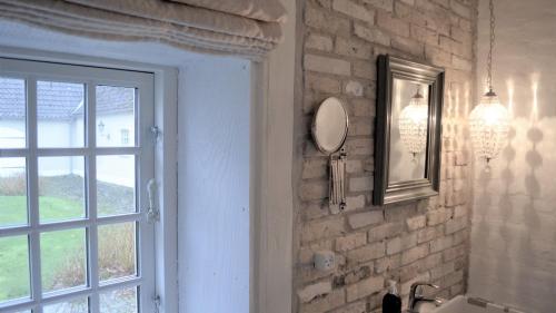 a bathroom with a sink and a mirror and a window at Store Ejlstrup Bed & Breakfast in Odense
