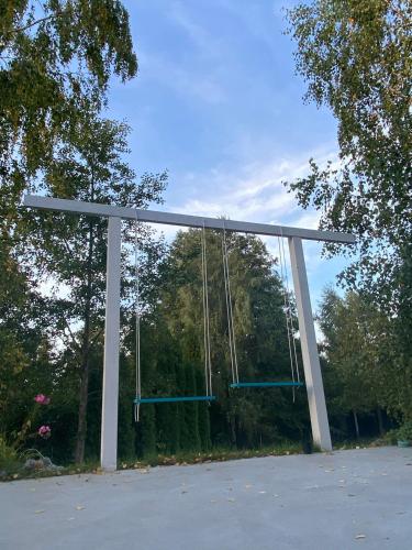 a large metal frame with swings in a parking lot at Lazurowy Brzeg in Przejma Wielka