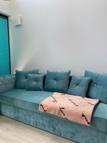 a blue couch with a blanket on it in a room at Lazurowy Brzeg in Przejma Wielka
