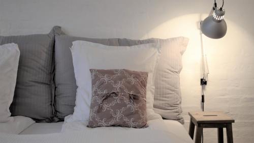 a pillow sitting on top of a bed with pillows at Store Ejlstrup Bed & Breakfast in Odense