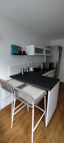 eine Küche mit einer Theke, einem Tisch und Stühlen in der Unterkunft SHARED Cozy place in Stuttgart's heart! in Stuttgart