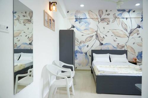 a bedroom with a bed and a wall with a flower mural at A/C room with Queen Bed Gachibowli in Hyderabad