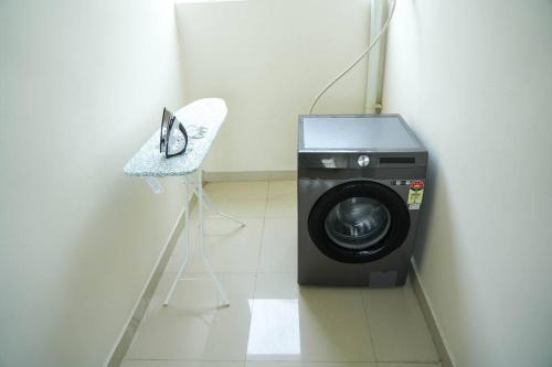 - Lavadora en una habitación con silla en A/C room with Queen Bed Gachibowli, en Hyderabad