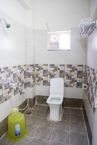 a bathroom with a white toilet and a shower at A/C room with Queen Bed Gachibowli in Hyderabad