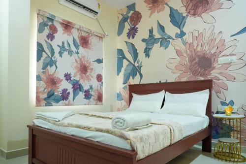 um quarto com uma cama com flores na parede em AC Queen Room Near Wipro Circle Gachibowli em Hyderabad