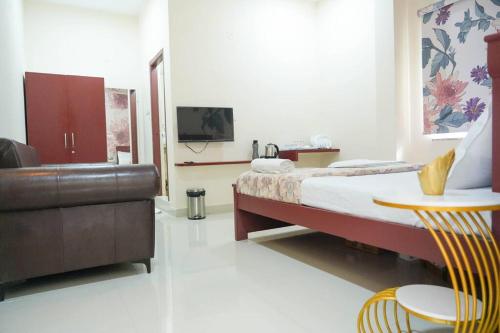 um quarto com uma cama, um sofá e uma mesa em AC Queen Room Near Wipro Circle Gachibowli em Hyderabad