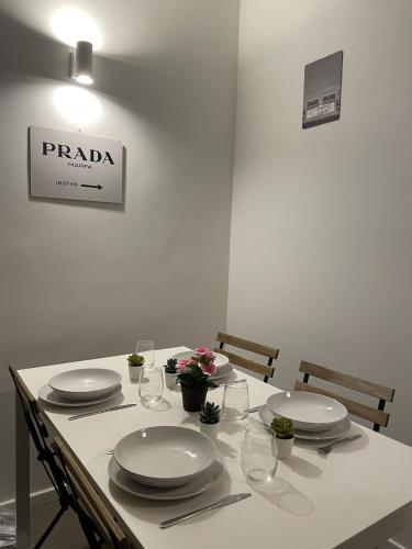 a white table with plates and glasses on it at Appartamento Duomo-Porta Romana in Milan