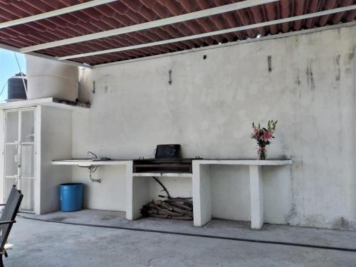 ein weißer Tisch mit einer Vase Blumen drauf in der Unterkunft Villa San Rafael in Tepetzingo