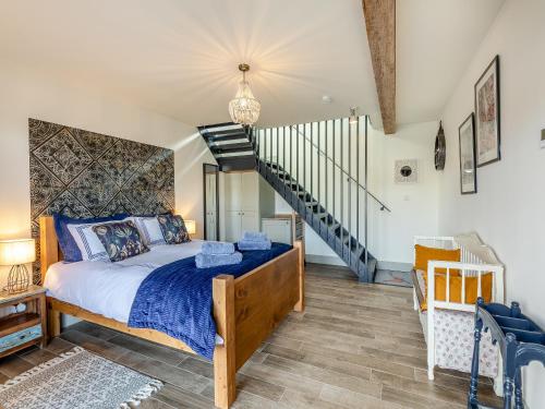 a bedroom with a bed and a staircase at The Granary - Uk43356 in Branxton