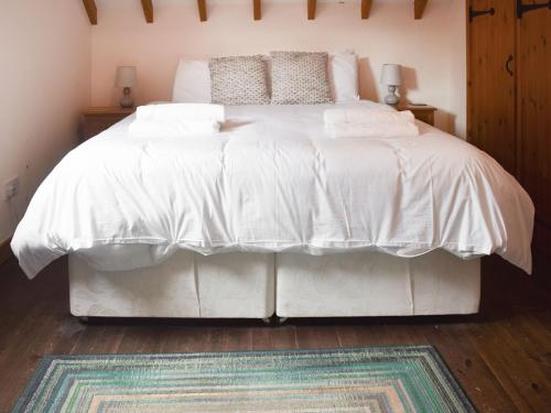 a white bed with a white comforter and pillows at Uk46715 - The Coach House in Plumstead