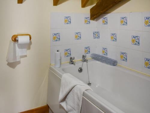 a bathroom with a bath tub with a towel at Uk46715 - The Coach House in Plumstead