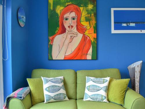 Blue Waters في ويماوث: غرفة معيشة بها أريكة و لوحة لسيدة