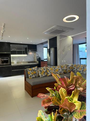 a living room with a couch and a kitchen at Apartamento Chique frente ao mar in Flecheiras