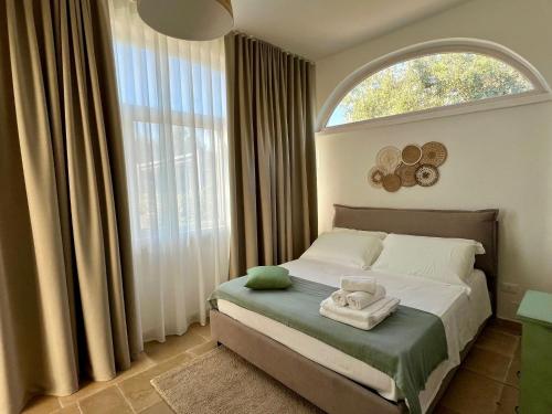 een slaapkamer met een bed en een groot raam bij Villa 32 Ostuni - Charming House with Pool in Ostuni