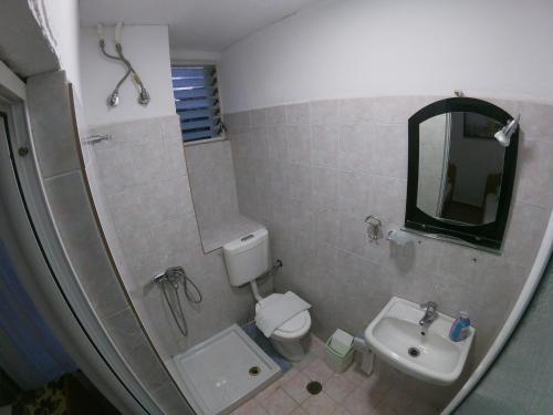 uma casa de banho com um lavatório, um WC e um espelho. em Casa Mia Economy Condos em Sarandë