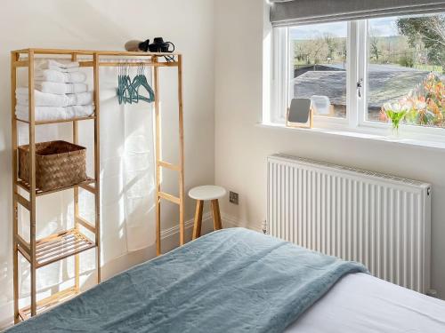 a bedroom with a bed and a window at Elizabeth Cottage in Glossop