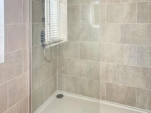 a bathroom with a shower with a tub at Elizabeth Cottage in Glossop