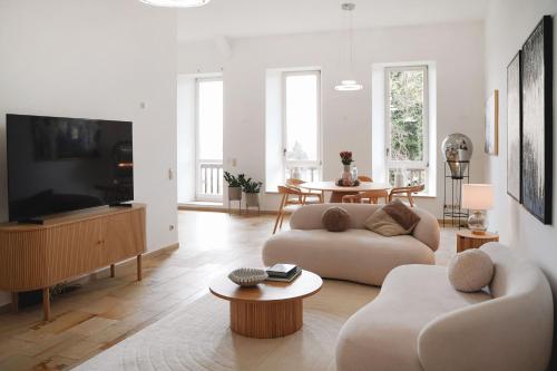 a living room with a couch and a tv at LOEWENHERZ HOMES Luxury Apartment - Stadt- und Seenähe - fellnasenfreundlich - lichtdurchflutet in Stephanskirchen