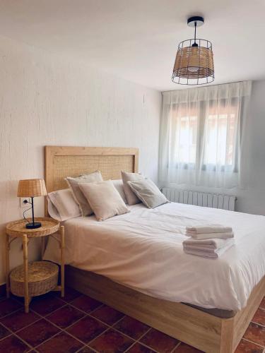 a bed with white sheets and pillows in a bedroom at El Capricho de la Serranía IV in Tragacete
