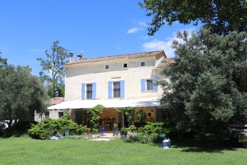 uma grande casa branca com árvores no quintal em Mas des Cerisiers SPA-SAUNA inclus pour tous les logements em Avignon