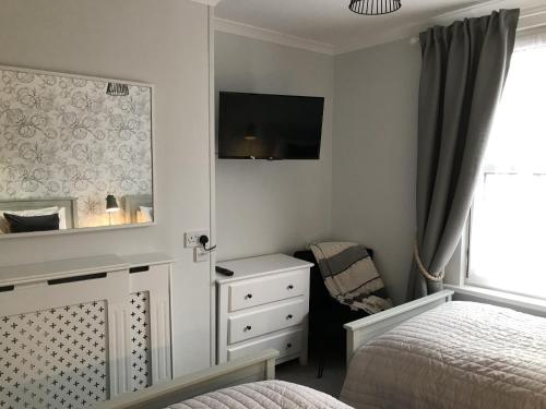 een slaapkamer met een bed, een dressoir en een spiegel bij The Glastonbury Townhouse B&B in Glastonbury
