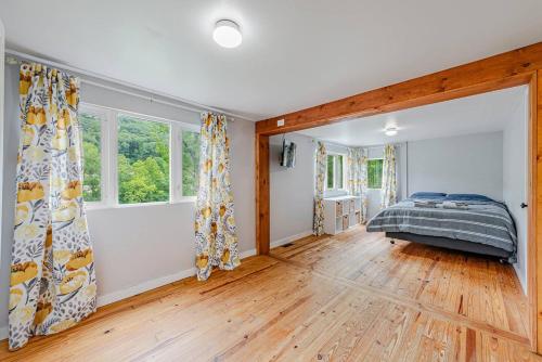 1 dormitorio con 1 cama en una habitación con suelo de madera en Pet Friendly Creekside Cabin At Darlington, en Ligonier