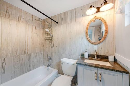 a bathroom with a toilet and a sink and a mirror at Pet Friendly Creekside Cabin At Darlington in Ligonier