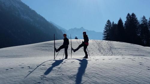 two people standing on a snow covered slope with skis at Ferienwohungen Familie Schröttle in Sonthofen
