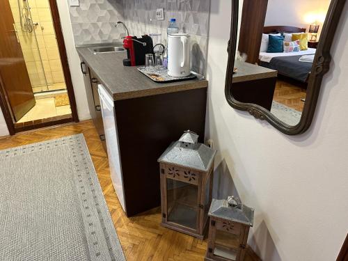 een kleine keuken met een wastafel en een spiegel bij Beatrix Suites in Budva