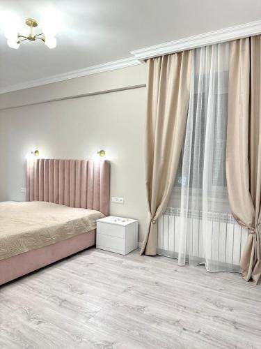 a bedroom with a bed and a window with curtains at Guest House Gayane in Gyumri